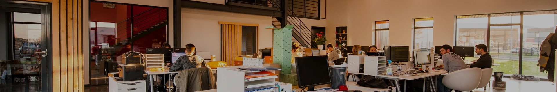 Open office workspace with desks, chairs, and computer monitors
